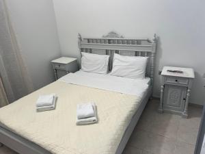 a bedroom with a bed with two towels on it at Kelenis Apartments in Karterados +13 photos