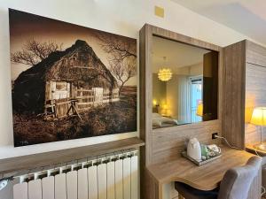 a room with a picture of a barn on the wall at Hotel Regina in Grado