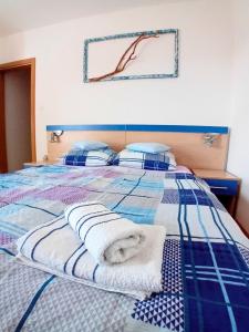 a blue and white bed with towels on it at Apartments Bambi in Lun