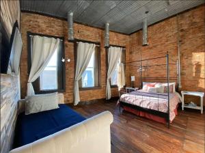 a bedroom with a bed and a couch and some windows at Eighteen-Ninety Sleepover in Casey