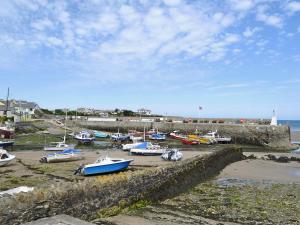 a bunch of boats are parked in a harbor at Quayside in Cemaes Bay