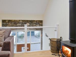 a living room with a fireplace and a couch at Mary Rook Cottage - Uk1369 in Keswick