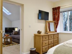 a bedroom with a bed and a dresser with a mirror at Mary Rook Cottage - Uk1369 in Keswick