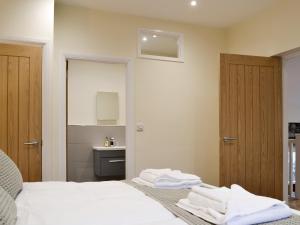 a bedroom with a bed with white sheets and a bathroom at Mary Rook Cottage - Uk1369 in Keswick
