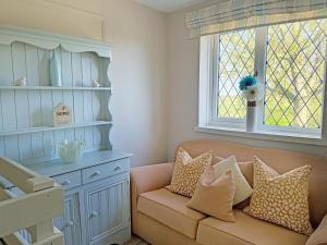 a living room with a couch and a window at Ash Cottage E1224 in Addlethorpe