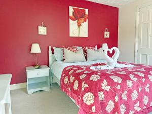 a red bedroom with a bed with a red wall at Ash Cottage E1224 in Addlethorpe +26 photos