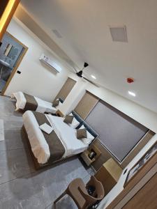 a large bedroom with two beds and a glass wall at Hotel Royal Heritage in Gandhinagar