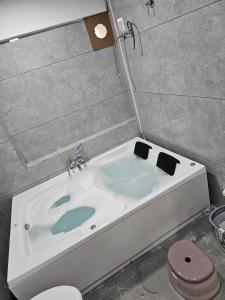 a bath tub in a bathroom with a toilet at Hotel Royal Heritage in Gandhinagar +14 photos