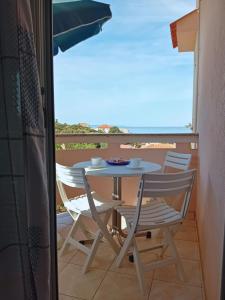 a table and chairs on a balcony with a view at Apartments Bambi in Lun