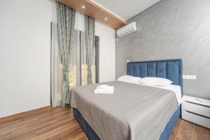 a bedroom with a bed with a blue headboard and a window at Resort Bevilacqua in Budva +89 photos