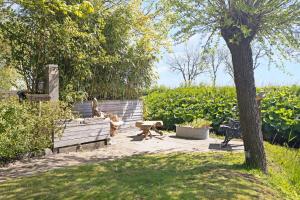 two dogs sitting on a bench in a garden at Camping Oudesluis in Oudesluis