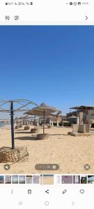 a picture of a beach with umbrellas in the sand at Full board rent in Ras Sedr