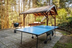 a ping pong table with a pavilion and a grill at Squirrel cottage Chata Veverica in Dolná Lehota
