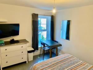 a bedroom with a bed and a desk and a window at Palace Guesthouse in Newquay