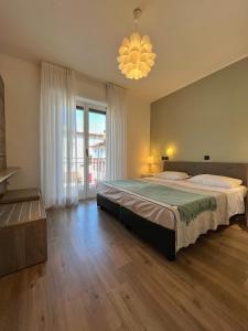 a bedroom with a large bed and a chandelier at Hotel Regina in Grado