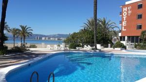 ein großes Schwimmbecken neben einem Gebäude in der Unterkunft Hotel Sicania in Cullera