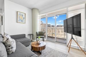 a living room with a couch and a tv at Toronto Harbourview Suites with free parking in Toronto