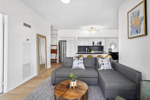 a living room with a gray couch and a table at Toronto Harbourview Suites with free parking in Toronto