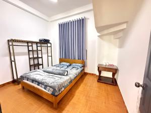 a bedroom with a bed and a radiator and a table at Mây HomeStay in Da Lat