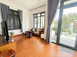 a living room with a couch and a tv at Mây HomeStay in Da Lat