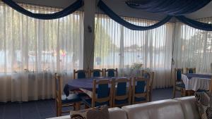 a dining room with a table and chairs and windows at Marina House in Sulina