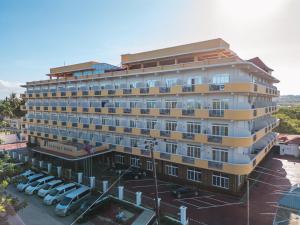 a large building with cars parked in a parking lot at Seascape Hotel in Dar es Salaam