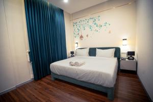 a bedroom with a large bed with a blue curtain at Aanya Taara Resort- Mettupalayam in Mettuppālaiyam