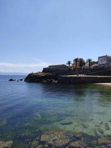 a body of water with a beach and buildings at Piso Gallega in Finisterre