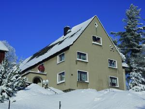 a large house with snow on the ground at Zimmervermietung Karsch in Neustadt in Sachsen