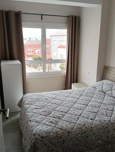 a bedroom with a bed and a large window at Piso Gallega in Finisterre
