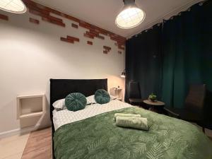 a bedroom with a green bed with two pillows at -Mała in Kielce