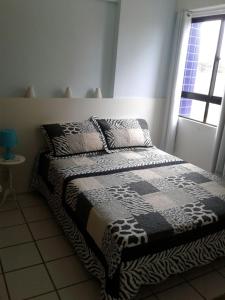 1 cama en un dormitorio con ventana en Grand Beach Flat Boa viagem, en Recife