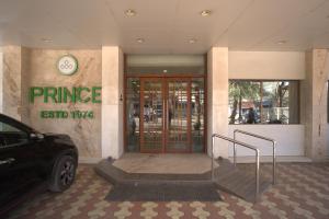a entrance to a building with a car parked outside at Hotel Prince, Bhuj in Bhuj