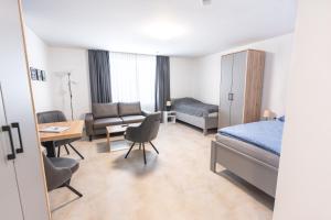 a hotel room with a bed and a desk and a couch at AN-Living Apartments in Emsbüren