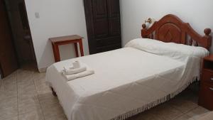 a bedroom with a bed with two towels on it at Ragas in Palma Sola
