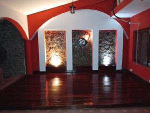 an empty room with red and white walls and wooden floors at Ragas in Palma Sola +2 photos