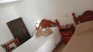 a bedroom with a bed and a dresser with two pillows at Ragas in Palma Sola