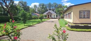 a house with a gravel driveway next to a building at Dans place in Moshi