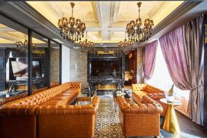 a living room with brown leather couches and a television at Hotel PALM GATE in Fukuoka