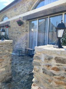 a lamp on a stone wall in front of a building at Charmant maison in Pontorson +7 photos