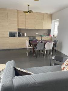 a living room with a couch and a table and chairs at Charmant maison in Pontorson