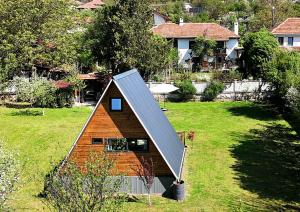 a small house with a pitched roof in a yard at Villa India A-Frame in Ledenik