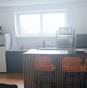 a kitchen with two bar stools and a sink and a window at Villa Mirage in Le Touquet-Paris-Plage +1 photo