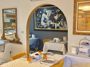 a dining room with two tables and a mirror at Meublè Tripoli in Grado