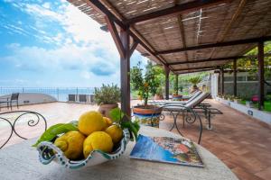 a bowl of lemons on a table on a patio at Il Giardino Dei Limoni in Praiano