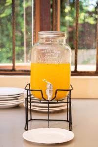 a jar of orange juice on a stand on a table at EvaZion River Side in Grande Rivière Sud Est