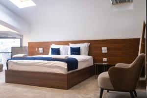 a bedroom with a large bed and a chair at Nam Hotel in Prizren