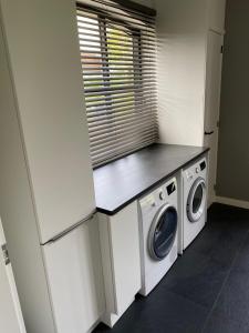 a laundry room with a washer and dryer at Het Atelier Schuring - Luxe vakantiehuis 78m2 in Numansdorp
