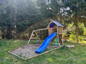 a playground with a slide in a yard at Ferienhaus mit Sauna am Waldrand in Friedrichroda