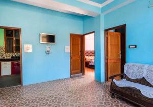 a room with blue walls and a bed and a kitchen at Indu BNB Shimla in Shimla